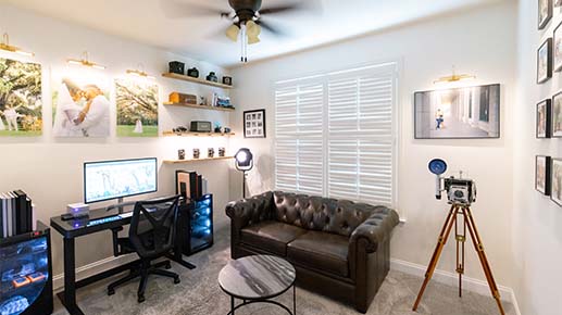 The Charleston Photo Art studio, with framed wedding prints on the walls, a viewing screen and a vintage plate camera on a tripod